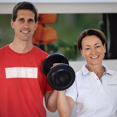 Unsere Physiotherapeuten halten gemeinsam ein Gewicht