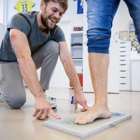 Therapeut bereitet einen Abdruck für die Füße
