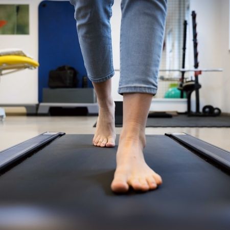 Person läuft barfuß auf dem Laufband