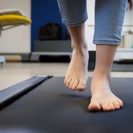 Person läuft barfuß auf dem Laufband