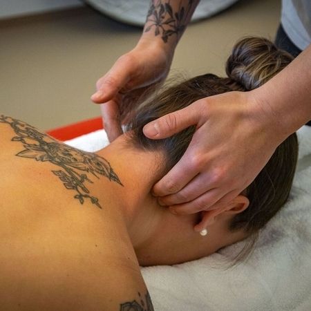 Medizinische Massagen - Masseurin behandelt den Nacken