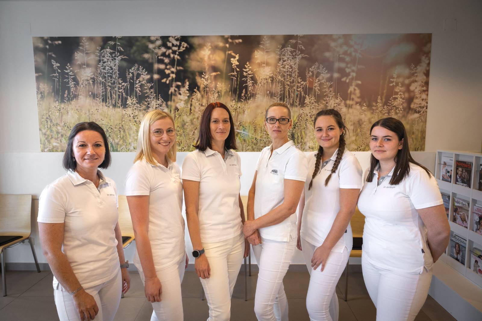 Unser Team - sechs Personen stehen zusammen vor einem Poster