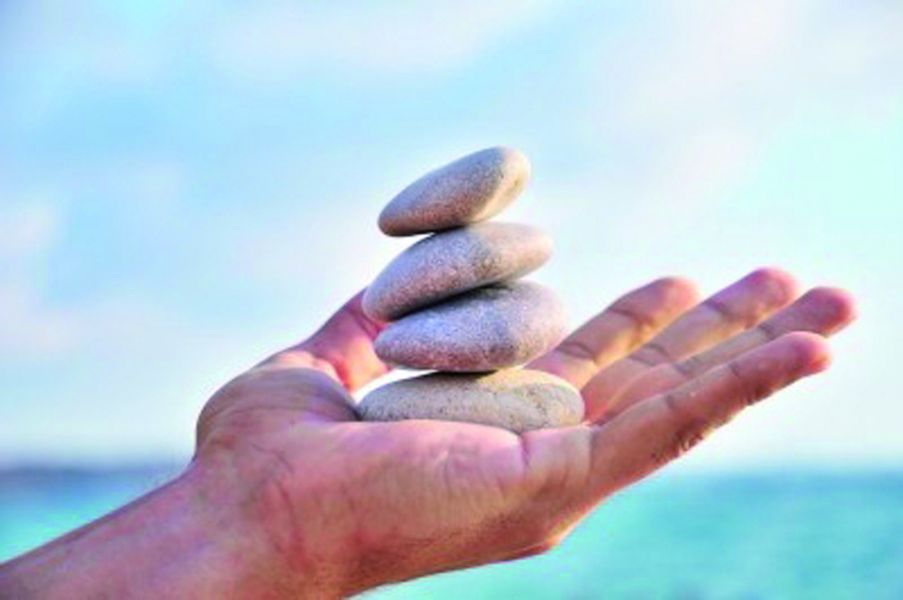 Hand hält Kieselsteine