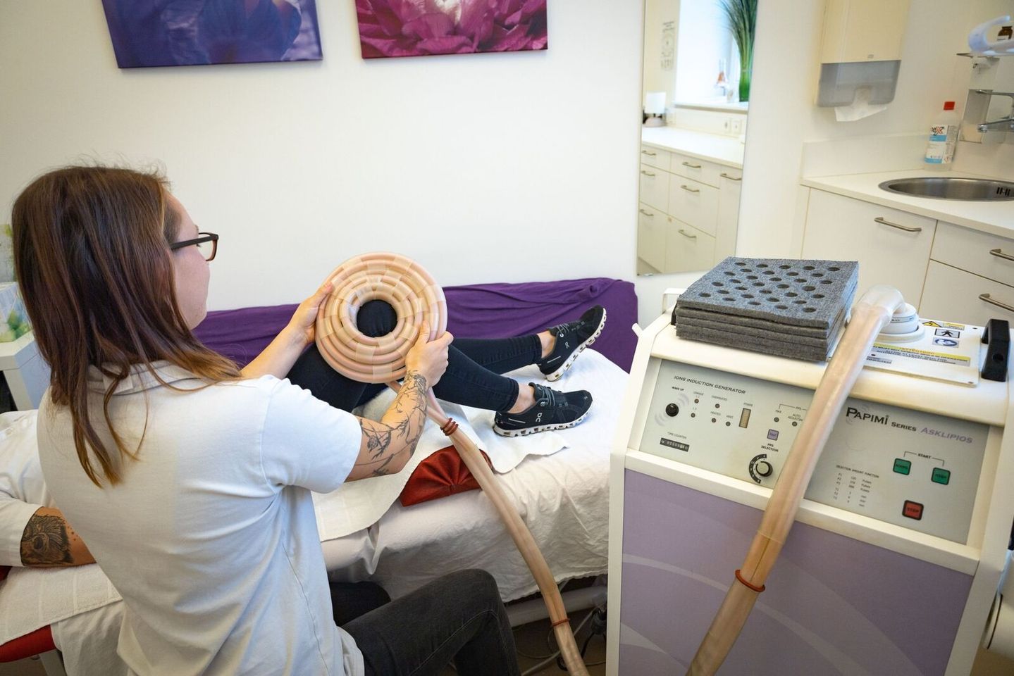 Patient wird mit einem Gerät am Knie behandelt