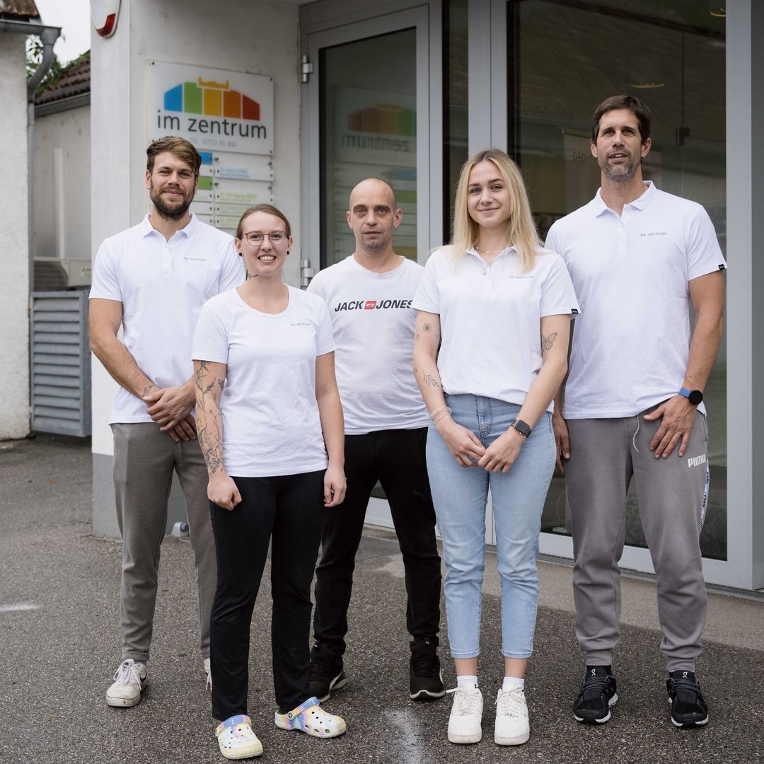 Unser Team - 4 Personen stehen vor dem Haupteingang