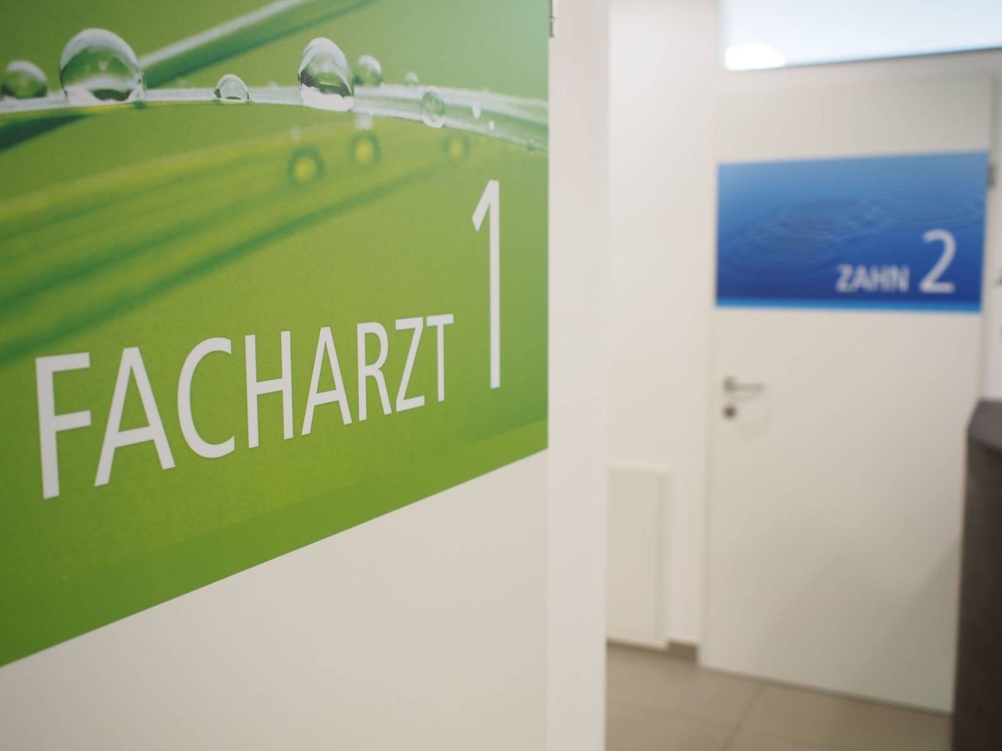 Eingangsbereich mit einem Plakat für den Facharzt